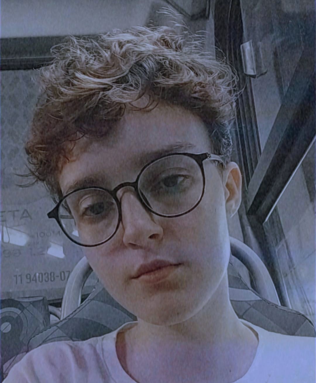Foto de uma mulher de cabelo curto, usando óculos e camiseta branca